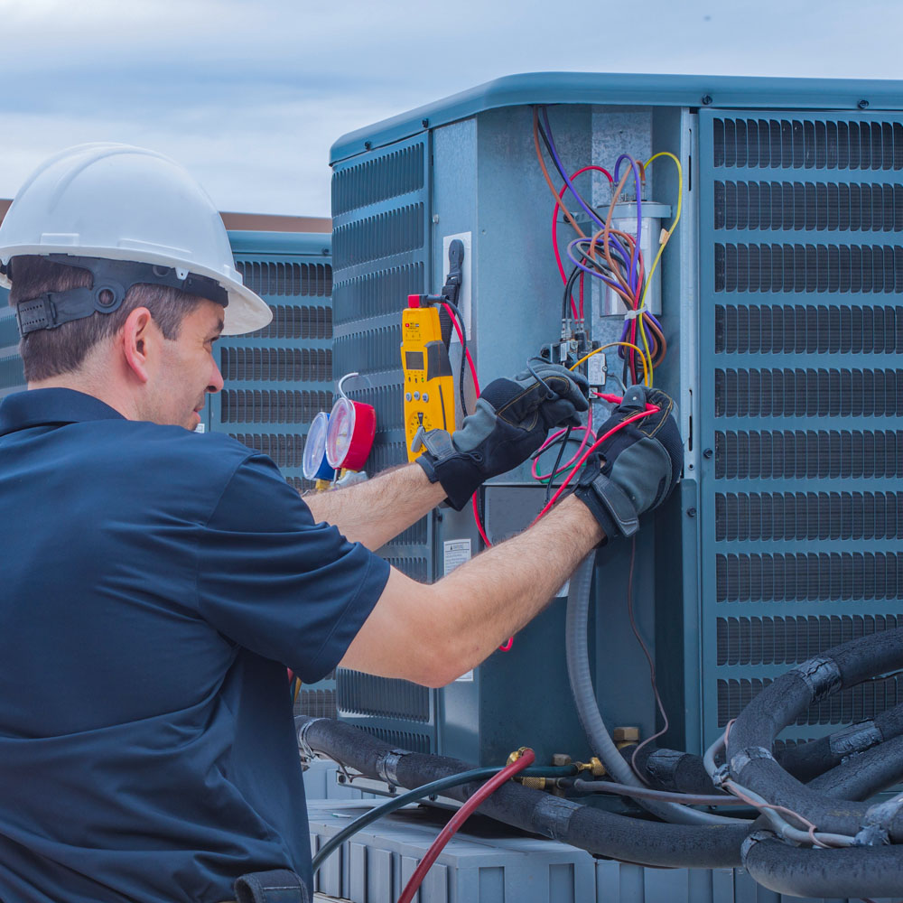 Technician checking for power on a rooftop condensing unit.